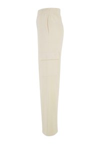 Pantalon de jogging beige clair en tissu doux, avec une poche cargo latérale et une taille élastique pour le confort.