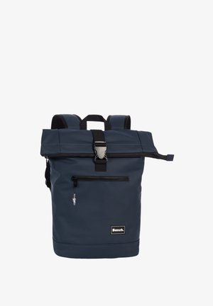 Donkerblauwe roll-top rugzak met een zwarte gesp, een ritssluiting aan de voorkant met een kleine bedel, gewatteerde schouderbanden en een Bench merklogo patch.