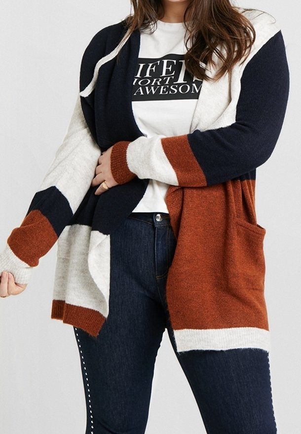 Cardigan en maille avec un mélange de bleu marine, blanc et rouille. Manches longues, devant ouvert et poches latérales. Texture douce et coupe décontractée.