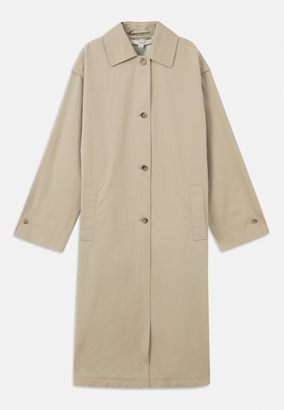 Beżowy płaszcz do kolan wykonany z mieszanki bawełny, z charakterystycznym kołnierzem, z przodu zapinany na guziki, z długimi rękawami i bocznymi kieszeniami naszytymi.