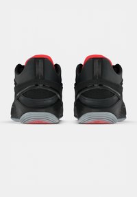 Μαύρα αθλητικά παπούτσια με κόκκινες λεπτομέρειες, με επενδεδυμένο γιακά, πάνελ από δίχτυ και ευλύγιστη γκρι σόλα με υφή για καλύτερο κράτημα.