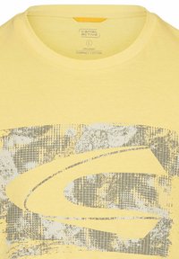 Gul økologisk bomulds t-shirt med rund hals. Har et stort gråt grafisk design, strukturerede mønstre og en afslappet pasform.