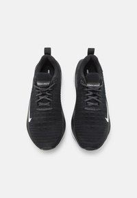 Melnas sporta kurpes ar teksturētu, austu virsu, kontrastējošu baltu swoosh logotipu un pelēkām auklām. Viegls dizains ar mīkstinātu zoli.