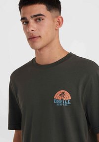 Donkergroene katoenen t-shirt met een kleine afbeelding aan de voorkant van een oranje zonsondergang, palmbomen en de tekst "O'NEILL SURF CO." in het blauw.