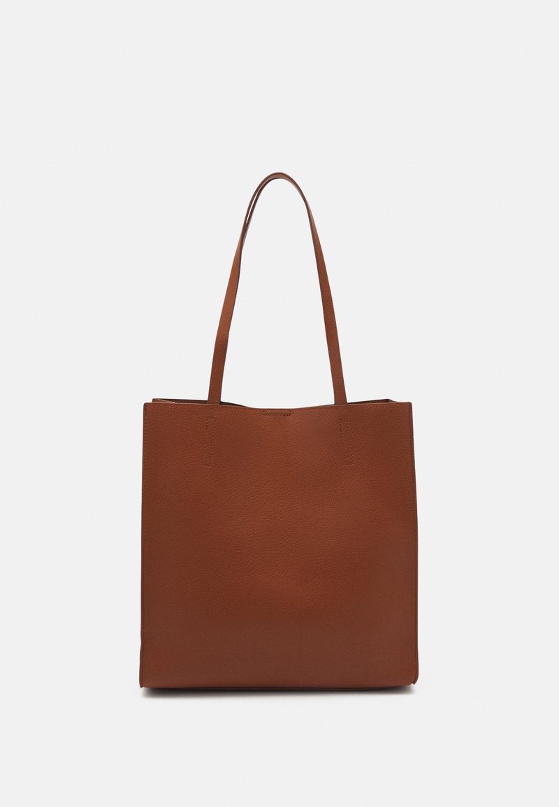 Sac fourre-tout en cuir marron avec une surface texturée, design plat, et deux longues poignées, ouverture en haut, sans poches extérieures ni ornements.