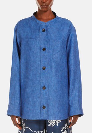Blauwe linnen overhemd met een ronde halslijn, lange mouwen, een sluiting met knopen aan de voorkant en twee borstzakken. Beschikt over een gestructureerde, lichte stof.