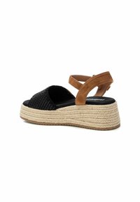 Parte superior de tela tejida negra con tira de ante marrón, suela de plataforma de yute estilo alpargata y suela de goma texturizada.