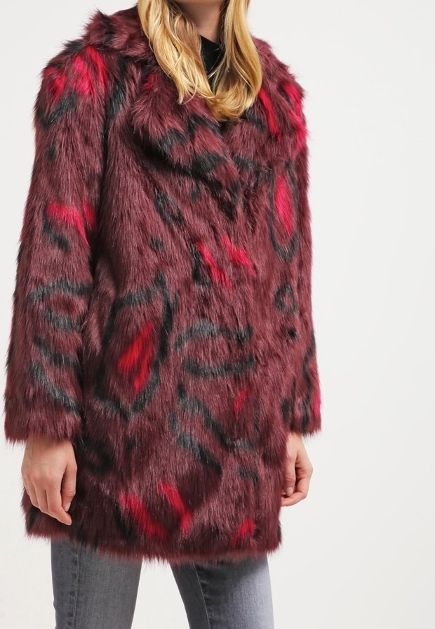 Abrigo de piel sintética color burdeos con estampado abstracto de leopardo en rojo y negro, mangas largas y un corte relajado, con un cuello ancho y textura suave.