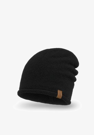 Musta neulepipo pehmeällä tekstuurilla ja rentolla istuvuudella. Sivussa on ruskea etiketti. Reunat on huoliteltu viimeistellyn ilmeen saavuttamiseksi.