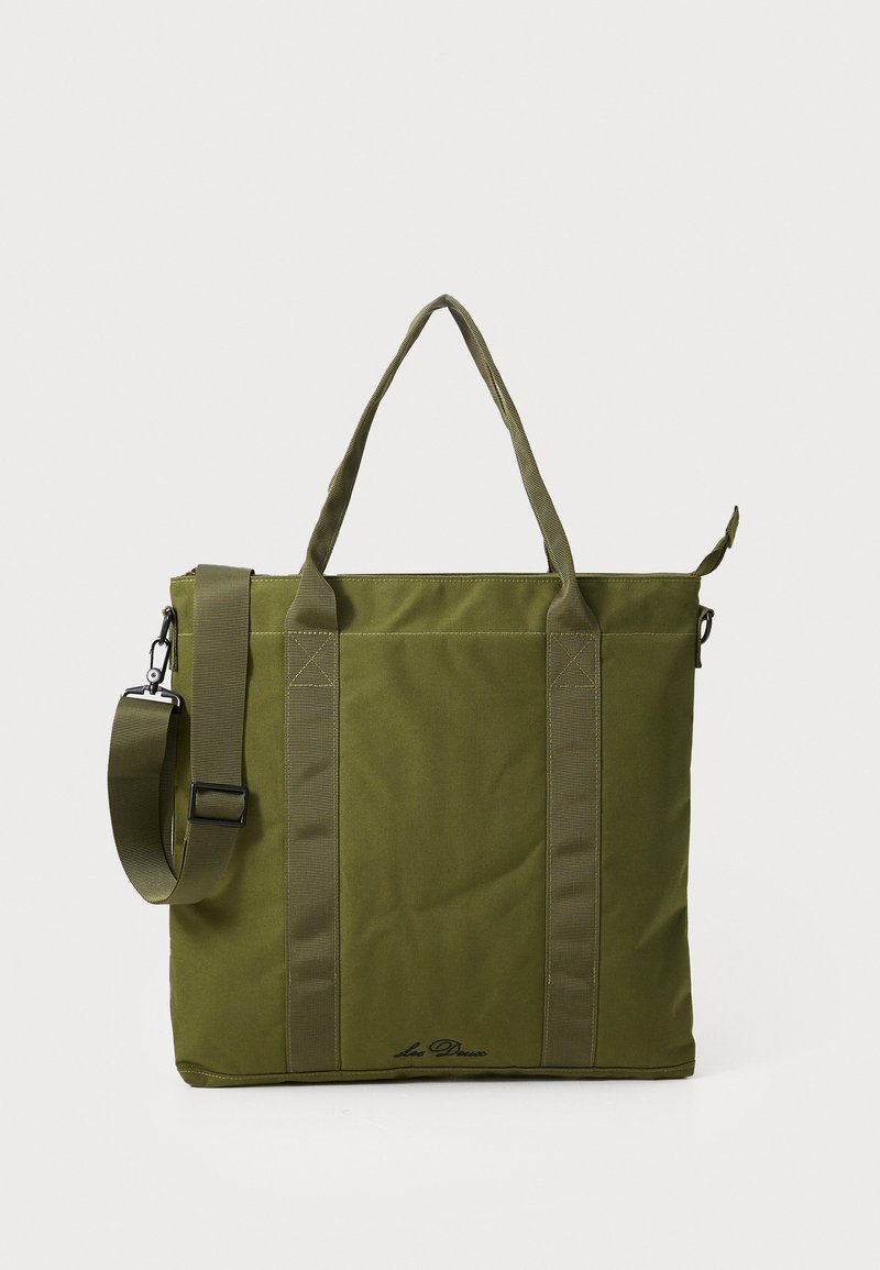 Olijfgroene tote bag met dubbele handvaten bovenaan en een afneembare schouderband. Kenmerkt zich door een textielstructuur en een subtiele logo-detail aan de onderkant.