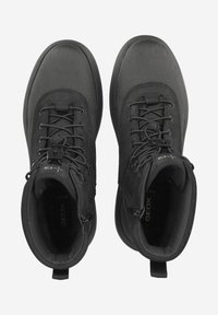Zwarte wandelschoenen met een gestructureerd oppervlak, vetersluiting, gevoerde enkelondersteuning en een trekhaak aan de achterkant. Ademend ontwerp voor comfort.