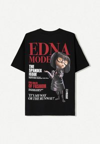 T-shirt noir avec un graphisme d'un personnage portant des lunettes. Le texte indique "EDNA MODE," "LE PROBLÈME DU SPANDEX," et "C'EST MA FAÇON OU LE TROTTOIR !"