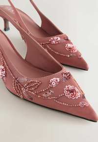 Vaaleanpunaiset kärjen suoran mallin slingback-kengät, jotka on valmistettu pehmeästä kankaasta, koristeltu paljeteilla ja helmikukka kuvioilla, joissa on kapea korko.