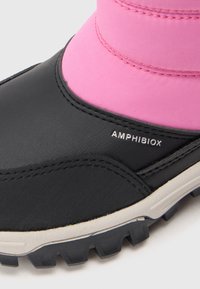 Bocanc negru impermeabil cu partea superioară din textil roz, talpă din cauciuc cu profil adânc și logo-ul "AMHIBIOX" în alb. Textură din piele netedă.