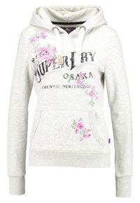 Sudadera con capucha de color gris claro, con cordones blancos, texto en negro "SUPERDRY OSAKA AUTHENTIC HERITAGE" y diseños de flores en punto de cruz en color rosa.