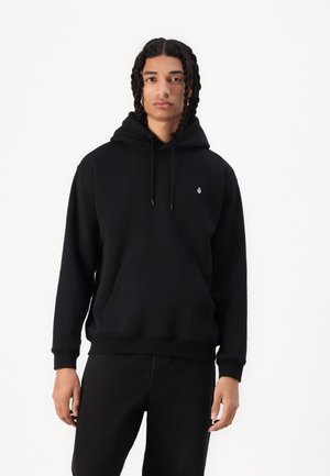 Hoodie noir avec une poche avant, capuche à cordon, et un petit logo sur la poitrine. Fabriqué dans un tissu doux et texturé.