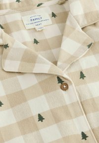Béžová a bílá kostkovaná košile s výšivkou zeleného stromu. Zapínání na knoflíky s hnědým knoflíkem. Měkká textilie. Štítek viditelný na límci.