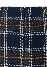 Navy blue and green patterned fabric with white and orange checks, featuring a textured weave and a central zipper closure.