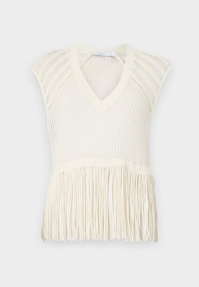 Knit cream vest top with a V-neck, short sleeves, and fringe detailing at the hem. Features a textured weave pattern throughout.