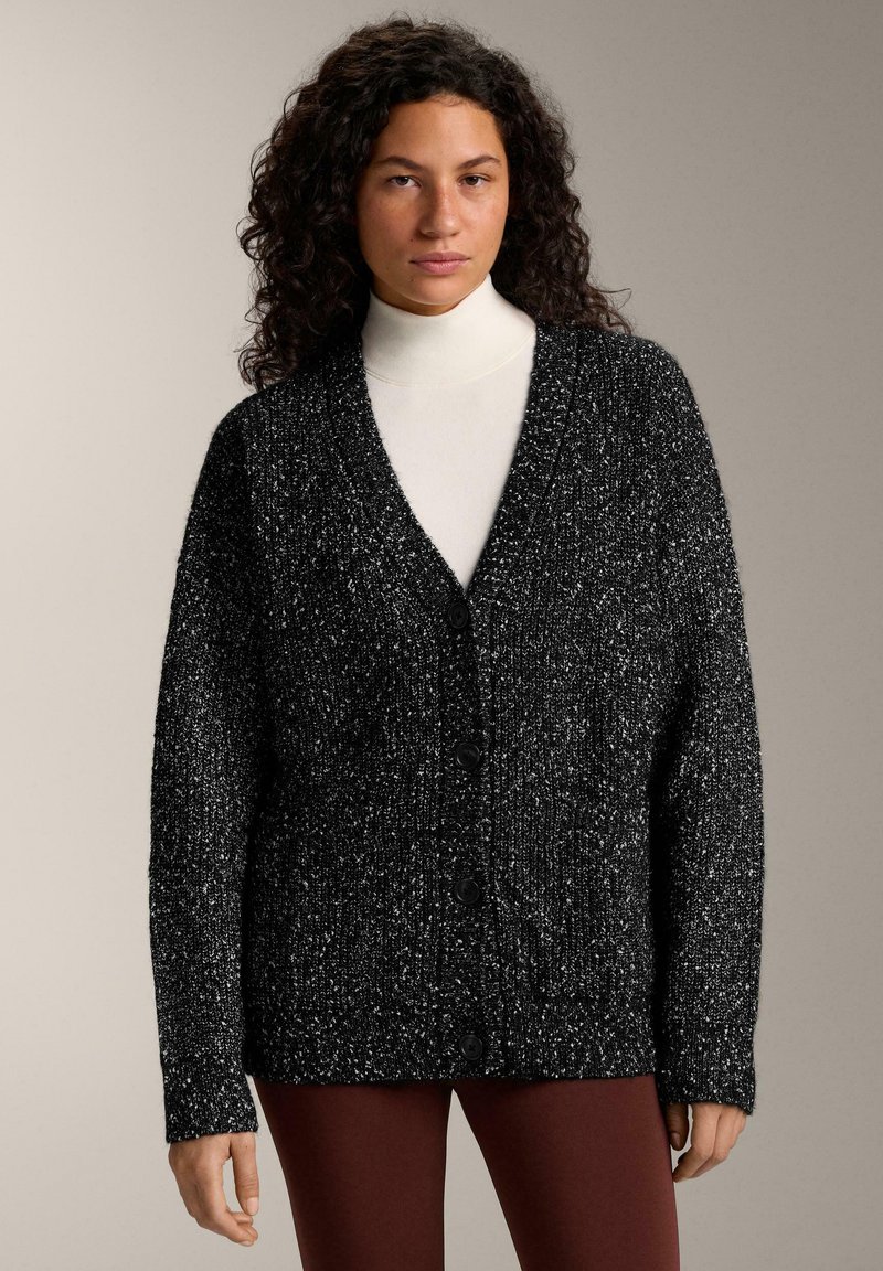 Black and white speckled cardigan with a v-neck, long sleeves, and button front closure, made from a textured knit material.
