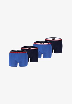 Männlicher Oberkörper trägt blaue Levi's Boxershorts mit weißem, rotem und marineblauem Markenbund und steht vor einfachem hellem Hintergrund.