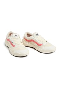 Zapatillas de lona blancas con acentos en rosa, con puntera redondeada, suelas texturizadas y logo característico en la lengüeta y el lado.