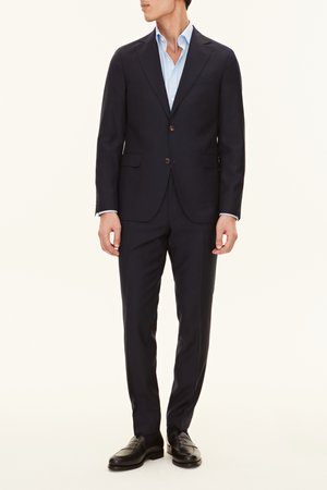 Marineblaues Sakko mit zwei Knöpfen, Revers und Fronttaschen; kombiniert mit einem hellblauen Hemd und schwarzen Loafers.