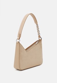 Beige ruskind handbag med et trekantet design, sølv hardware, lynlåslukning og en rem med brandnavnet i udskårne bogstaver.