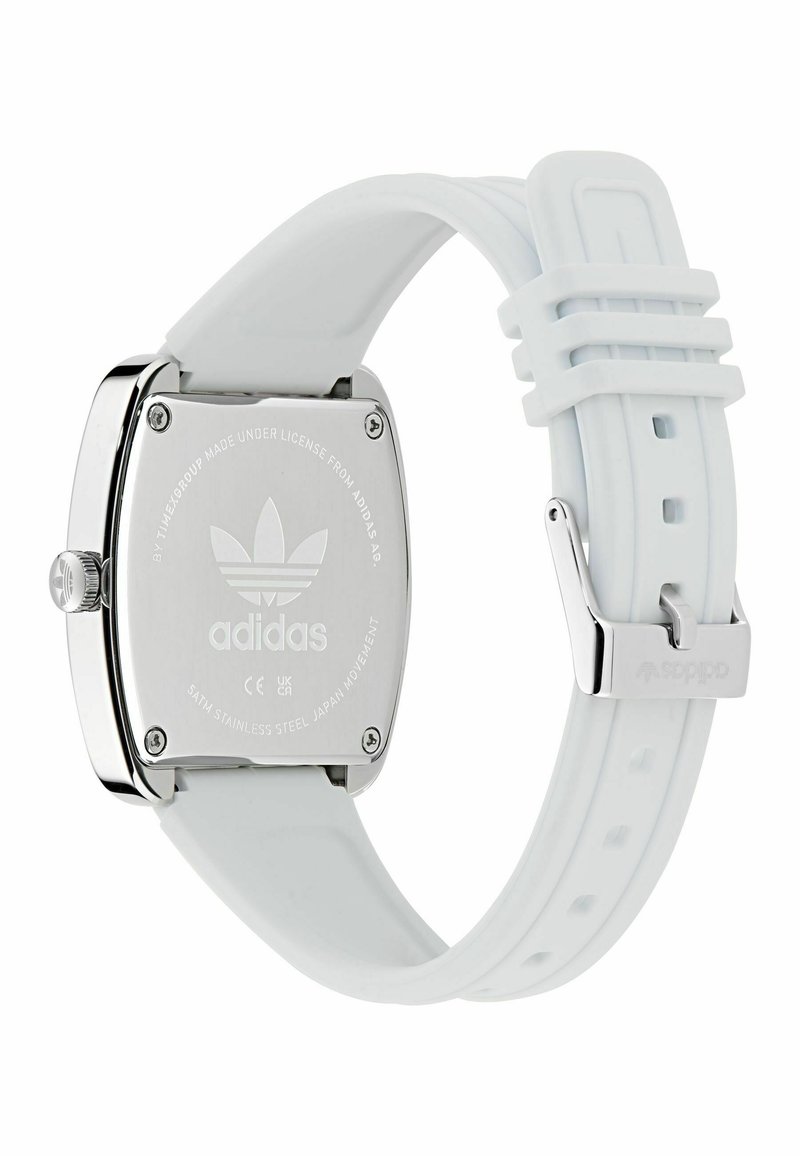 Vista posteriore dell'orologio Adidas con cinturino in silicone bianco, cassa in acciaio inox e logo e testo incisi sul retro della cassa.