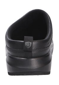 Scarpa nera con tomaia sintetica, retro arrotondato, collo imbottito e suola in gomma testurizzata. Presenta un piccolo logo sulla linguetta del tallone.