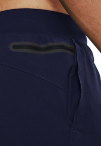 Los pantalones cortos deportivos en color navy cuentan con una tela suave, una cinturilla elástica y un bolsillo con cremallera segura en el costado para almacenamiento.