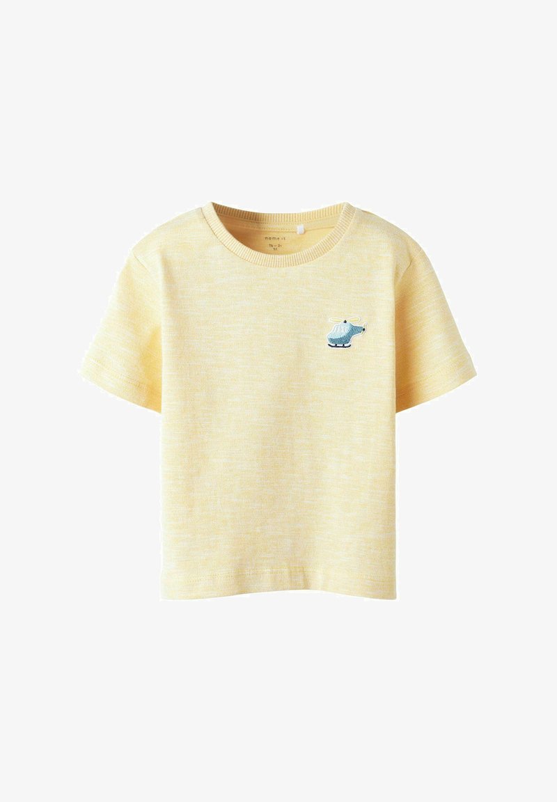 T-shirt de algodón amarillo con cuello redondo y mangas cortas. Presenta un detalle bordado de un helicóptero azul en el lado izquierdo del pecho.