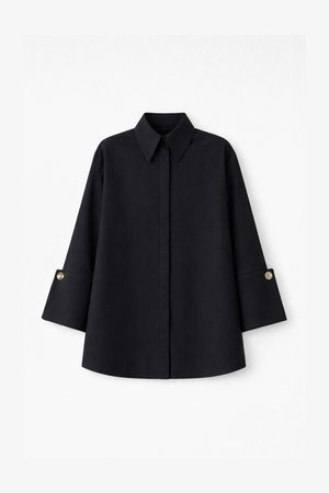 Black shirt with a point collar, long sleeves with gold button accents, and a relaxed fit. Smooth fabric with an even texture.
