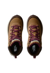 Brune tursko med lilla lisser, lerretsoverdel, polstret krage, gummisåle og logo på tungen; har en løkke bak på hælen.