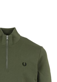 Sudadera con cremallera de color verde oliva y cuello alto, con un logo negro en el pecho y fabricada en un tejido suave y texturizado.