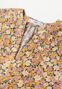 Blouse jaune et rose à motif floral avec col en V et détail froncé à l'encolure. L'étiquette de la marque indique MNG.