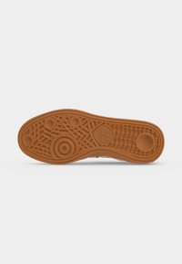 Σόλα παπουτσιού με υφή από καουτσούκ που περιλαμβάνει κυκλικά μοτίβα, υφασμένο τμήμα και χαραγμένο λογότυπο Adidas στο κέντρο.