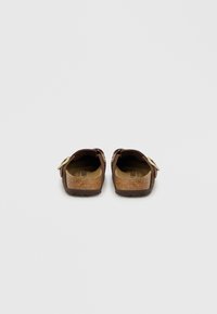 Καφέ σανδάλια φελλού με υφή στα πέλματα, ρυθμιζόμενο λουρί με μεταλλική κυκλική διακόσμηση και ελαφριά σόλα.