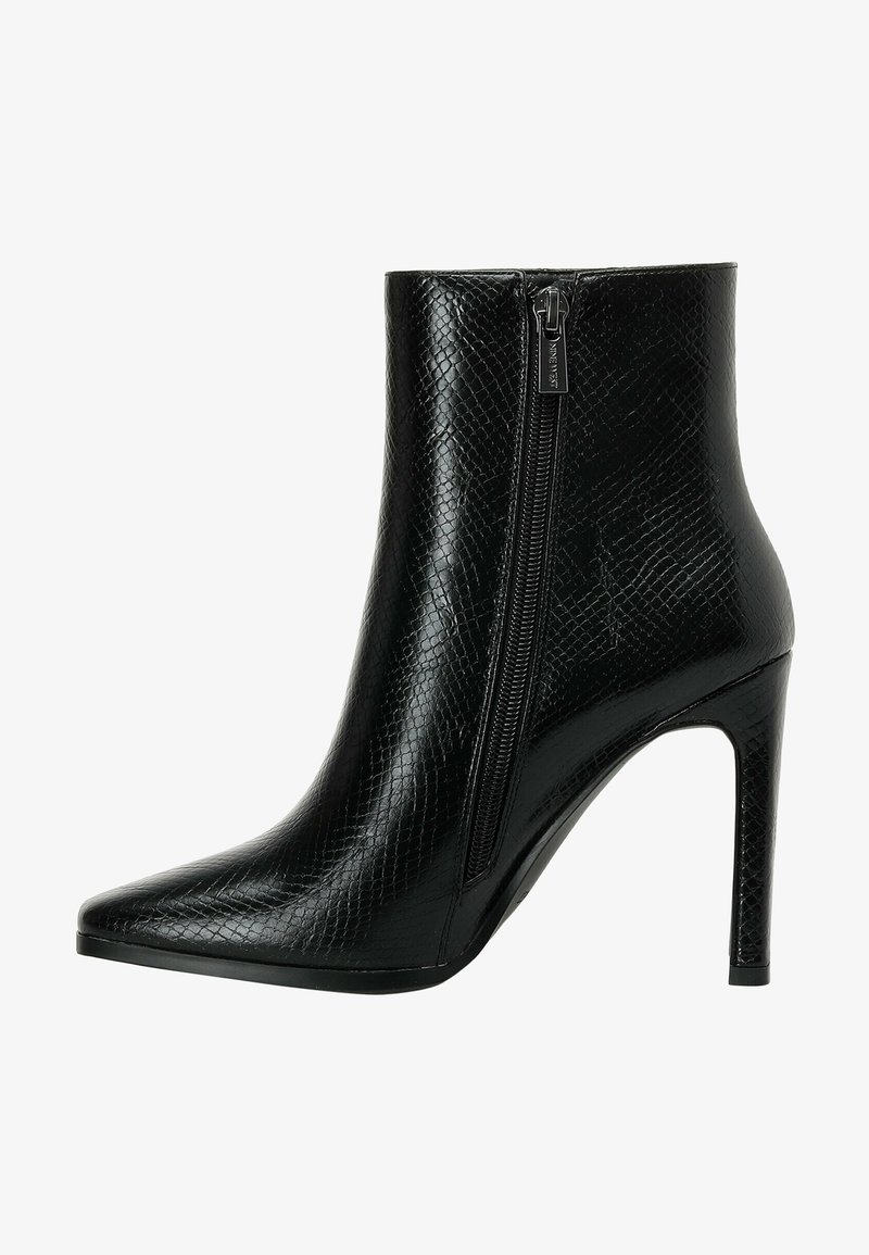 Svart ankelsko i texturerat läder med spetsig tå och hög stiletto-klack. Har en sidodragkedja för enkel på- och avtagning.