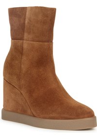 Bottine à talon compensé marron en daim à texture lisse, dotée d'une tige sans coutures et d'une semelle en caoutchouc solide pour l'adhérence.