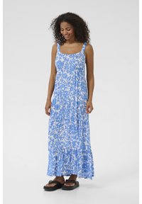 Blaues Blumen-Maxikleid mit quadratischem Ausschnitt, verstellbaren Trägern, gestuftem Saum und leichtem Stoff. Kombiniert mit schwarzen flachen Sandalen.