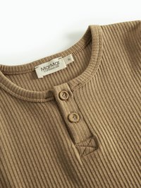 Bruine geribbelde langetermijnshirt met een ronde halslijn, sluiting met drie knopen en een geborduurd accentdetail nabij de zoom.