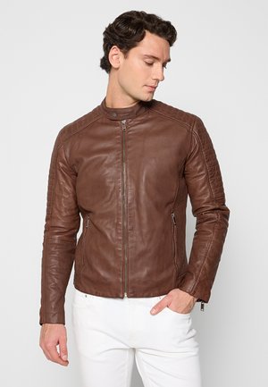 Braune Lederjacke mit hohem Kragen, taillierter Passform, Reißverschluss vorne und seitlichen Taschen. Strukturierten Schulterakzenten verleihen Detail.