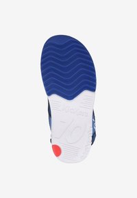 Suola di scarpa atletica blu con un motivo di tassellatura ondulata, intersuola bianca con il marchio "Kickers" e un accento rosso vicino al tallone.