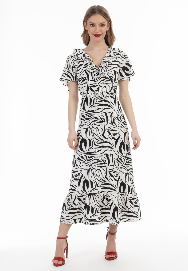 Zwart-witte zebra print maxi jurk met korte gerimpelde mouwen, een V-hals en een gelaagde zoom. Draag de jurk met rode hakken.