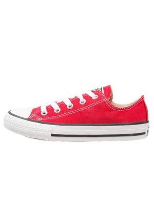 Baskets basses en toile rouge avec semelle en caoutchouc blanche, lacets blancs et détail à rayure noire, vues de côté.
