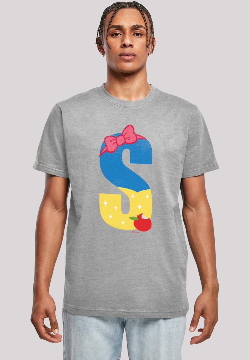Pelēka T-krekls ar lielu krāsainu "S" grafiku, kas ietver zilu, dzeltenu un sarkanu krāsu, rozā loku un stilizētu ābola detaļu.