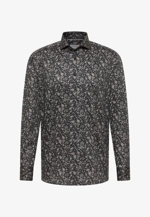 Camicia nera a maniche lunghe con bottoni, decorata da un piccolo motivo floreale bianco e colletto classico su sfondo bianco.
