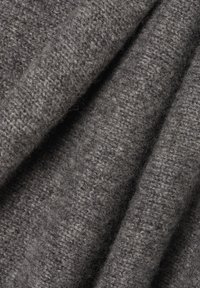 Grau Wolle Stoff mit einem strukturierten, gestrickten Muster. Das Material wirkt weich und gemütlich und zeigt verschiedene Grautöne der Fasern.