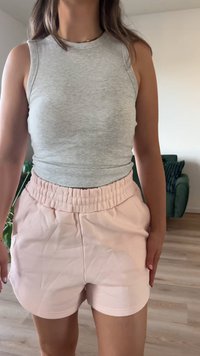 Γκρίζα ριγέ τοπ με τιράντες που συνδυάζεται με ανοιχτό ροζ σορτσάκι με ελαστική μέση, το οποίο διαθέτει λεία υφή και ίσια γραμμή.